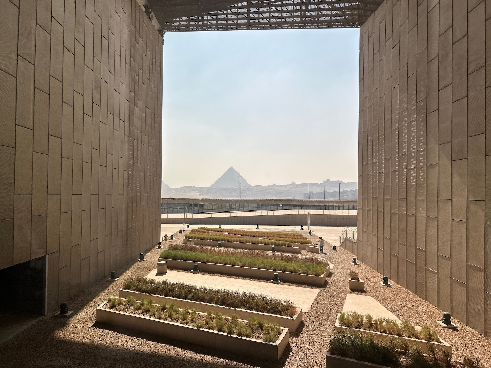 Grand Egyptian Museum with outdoor gardens and Great Pyramid of Giza in background