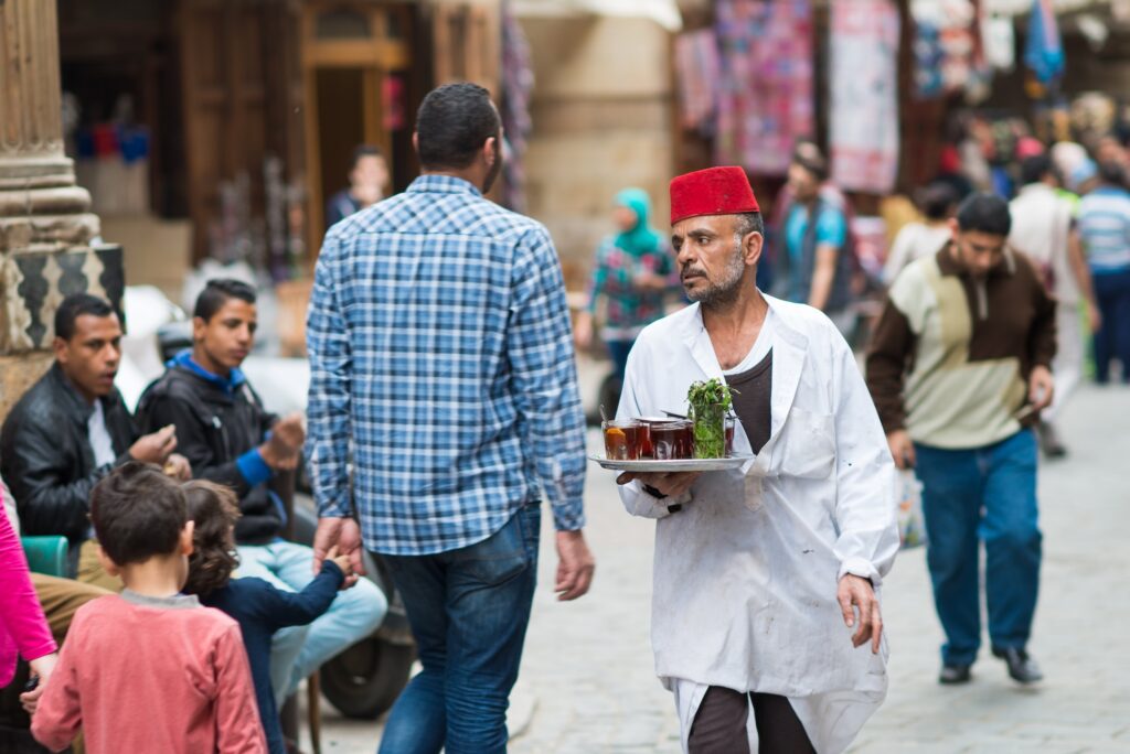 A tea house servant serves tea at historical Khan El Khalili Souq marketplace