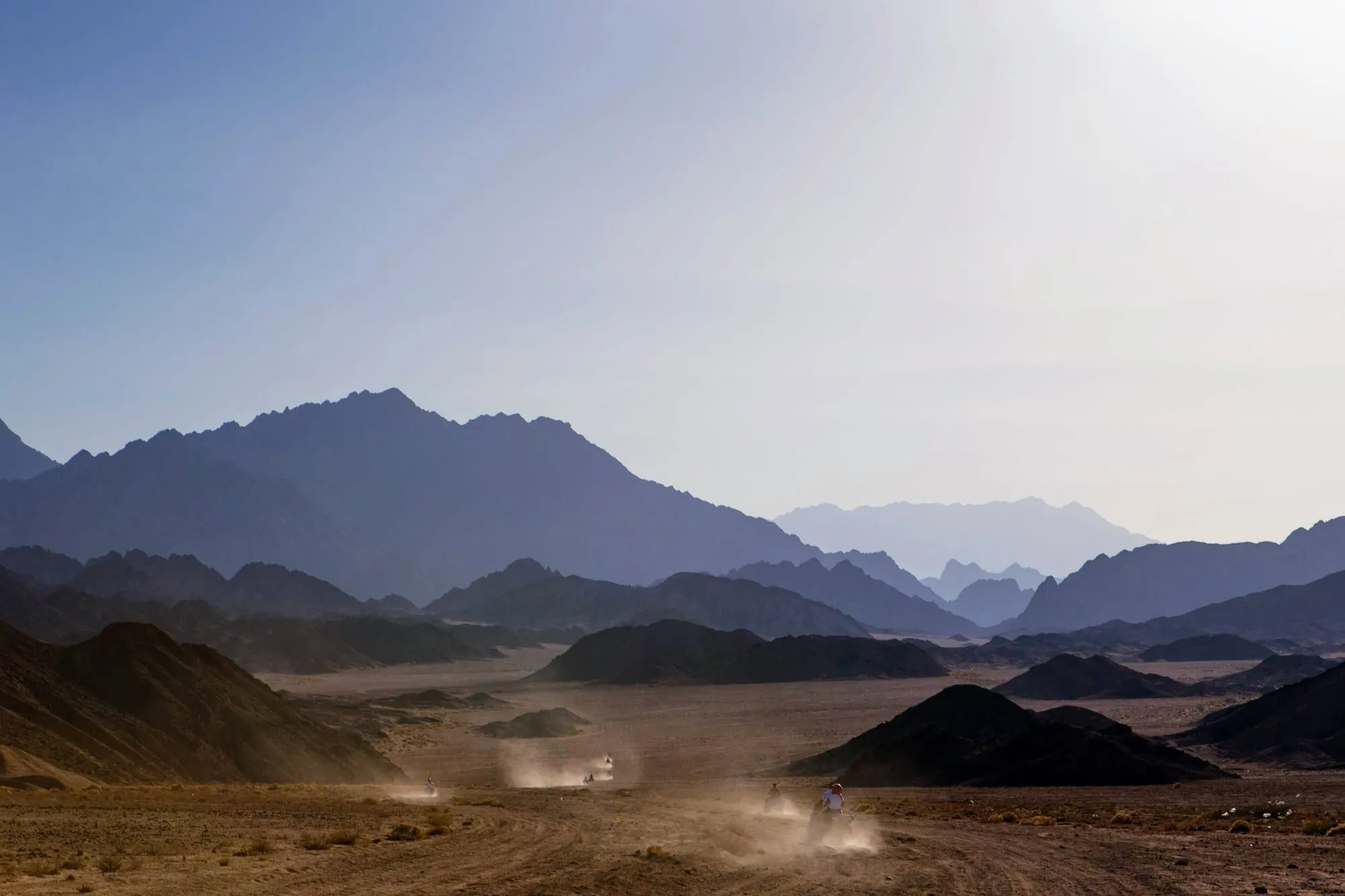 ATV riders in Nabq National Park desert landscape with mountain ranges