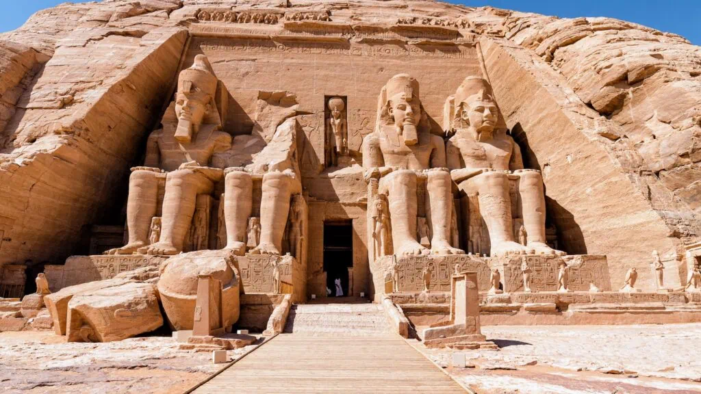 The facade of the Great Temple of Abu Simbel, with its four colossal seated statues of Ramses II carved into the sandstone cliff face in southern Egypt.