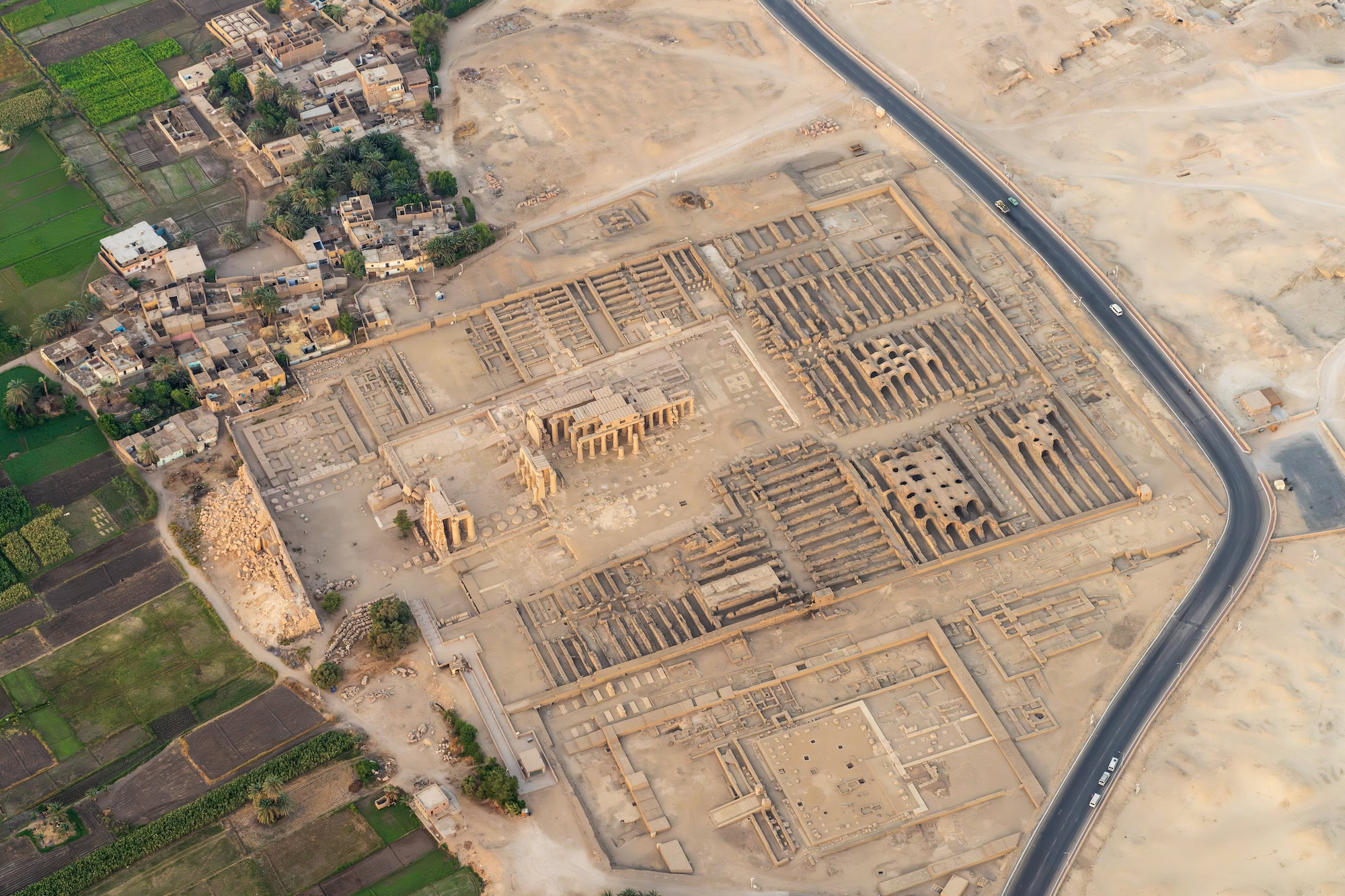 Aerial view of ancient Egyptian temple complex with columns and surrounding landscape