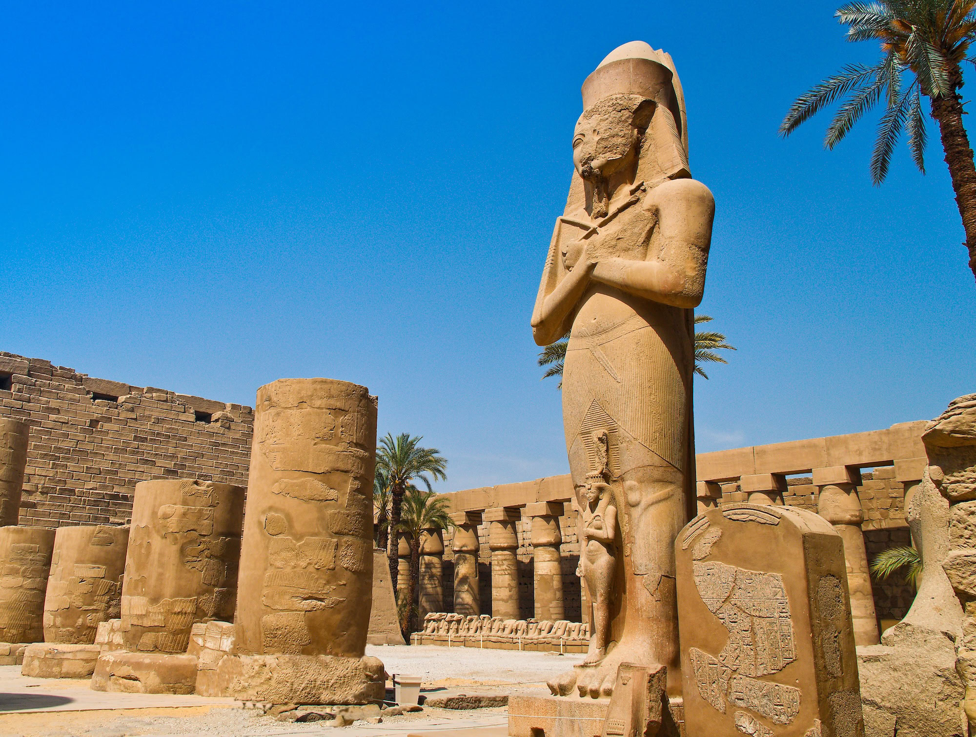 Estatua de faraón y columnas con jeroglíficos en el Templo de Karnak