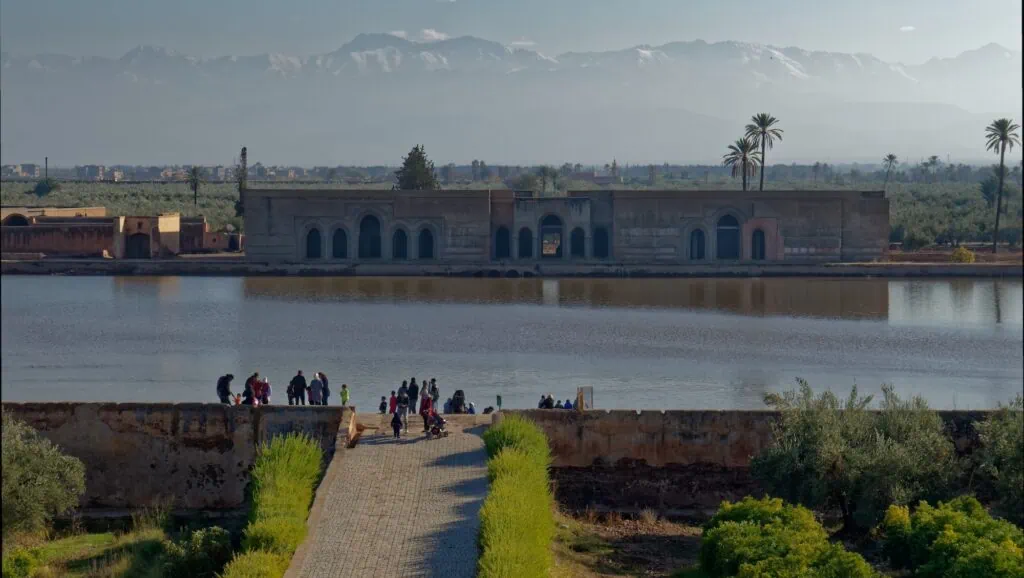 Agdal Basin with water reservoir, surrounding walls, and distant pavilion with Atlas Mountains in the background