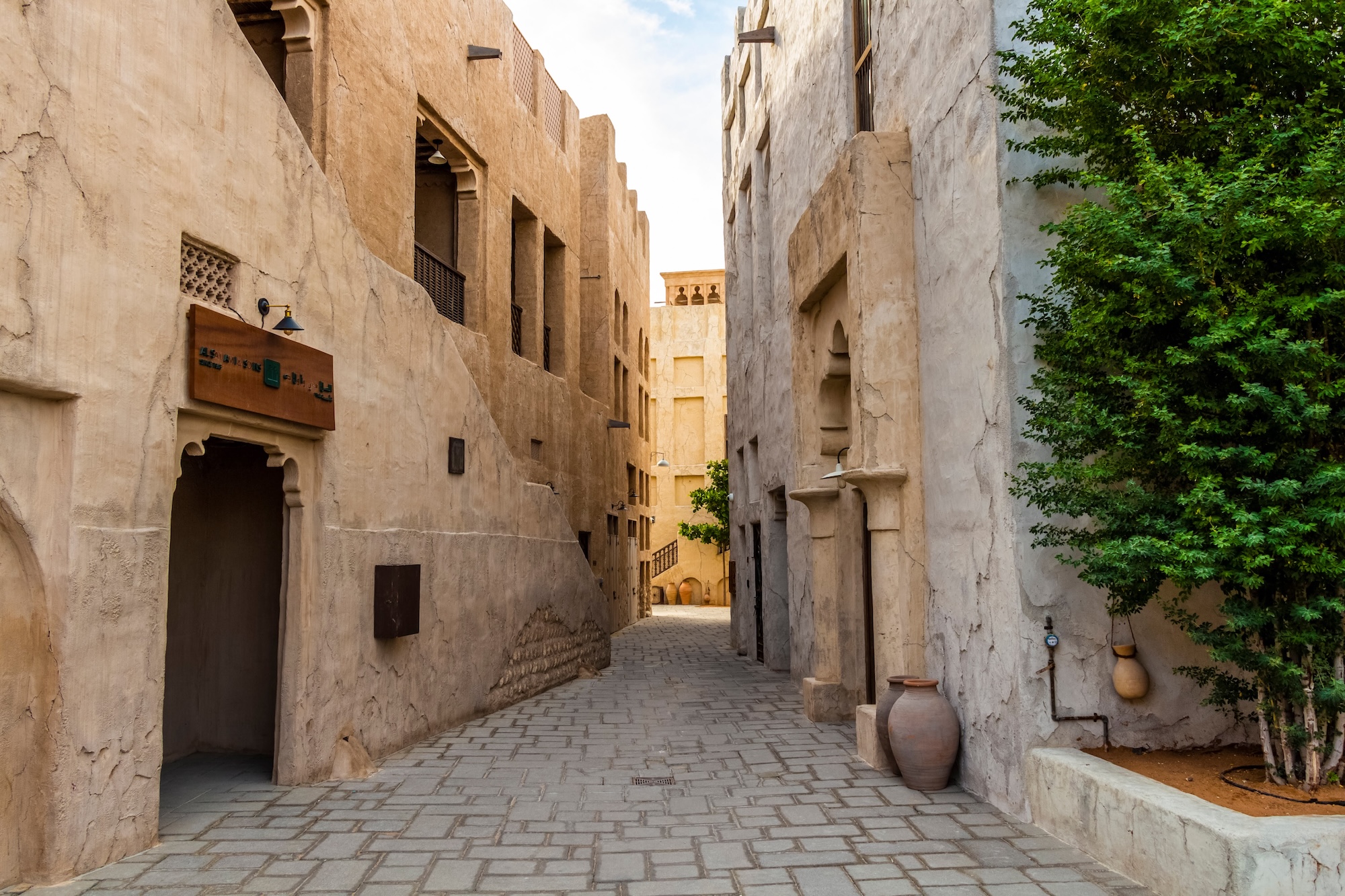Cobblestone street in Al Fahidi Historical Neighbourhood with traditional Arabian architecture and wind towers