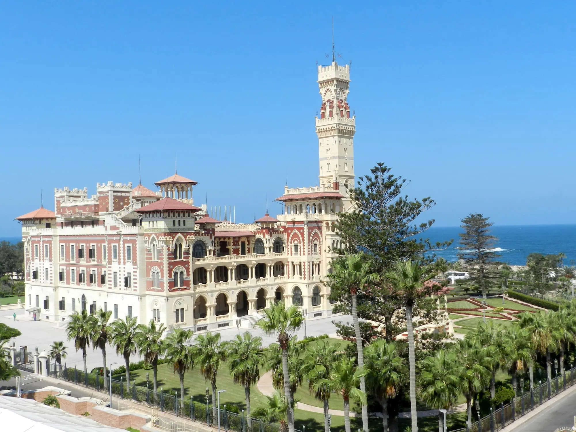 Majestic Montaza Palace with towers, arches, and palm trees in Alexandria
