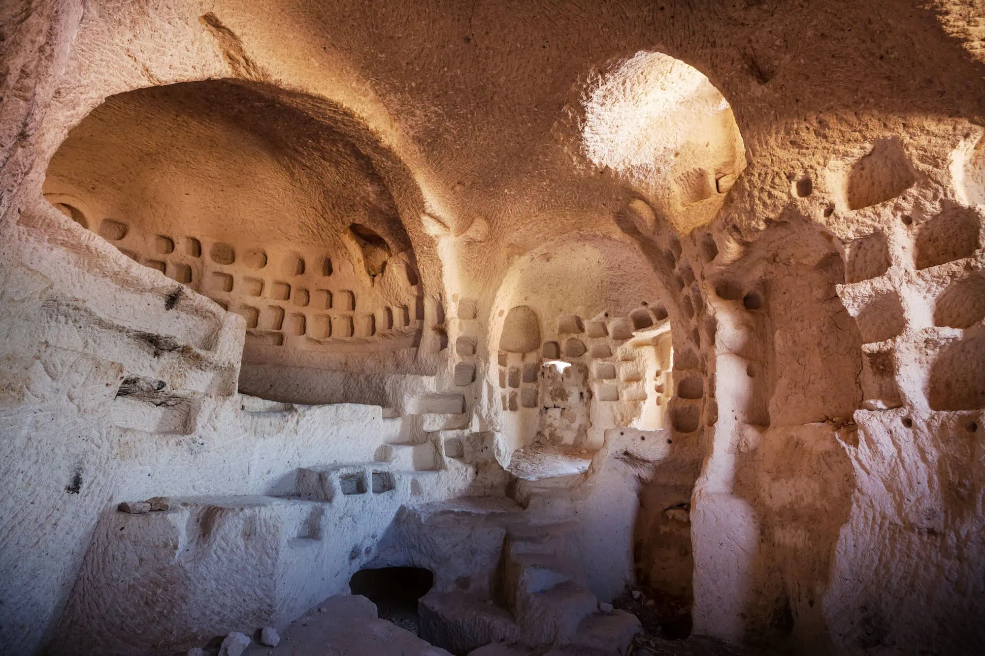 Interior of ancient rock-carved cave church in Cappadocia showing monastic architecture