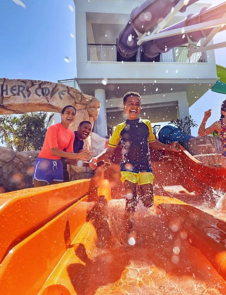 Aquaventure Waterpark showing a family water slide with a child exiting into a shallow splash pool at Atlantis The Palm, Dubai