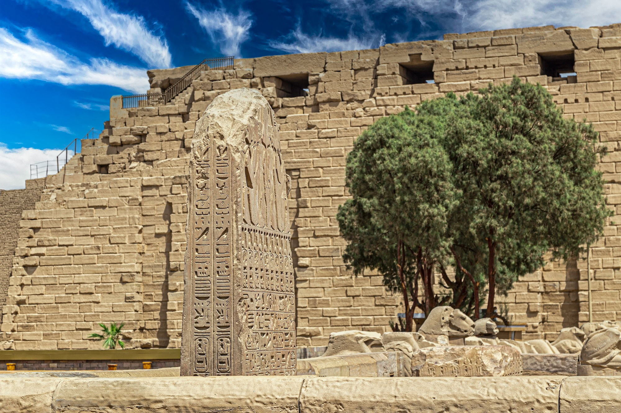 Hieroglyphic obelisk at Karnak Temple with ancient stone walls and ruins