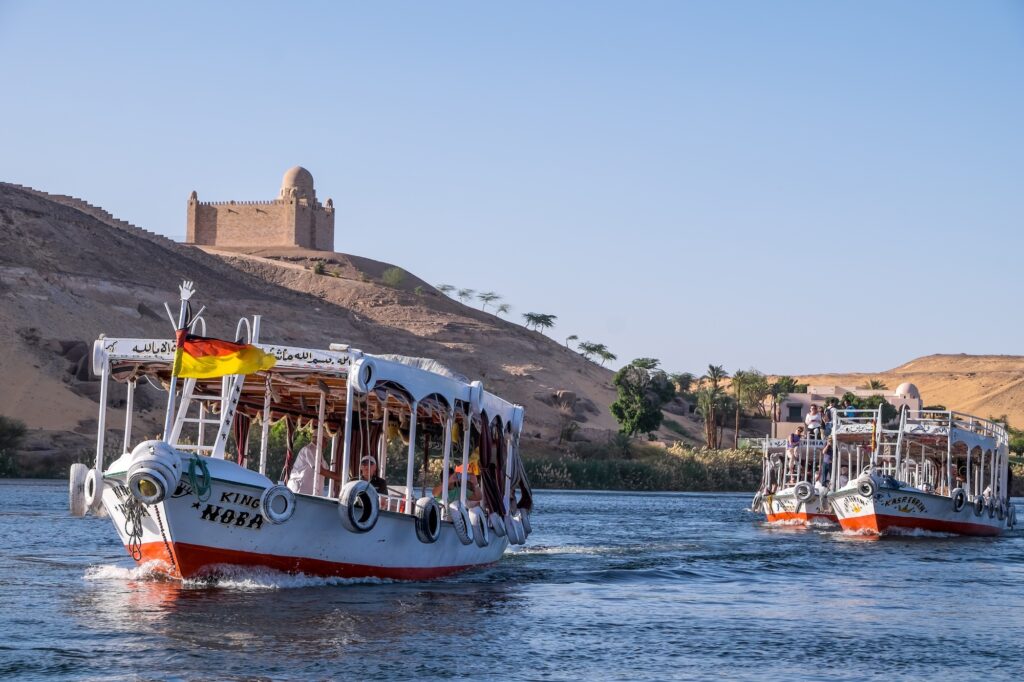 Tourist boats sailing on the Nile in front of the Aga Khan Mausoleum