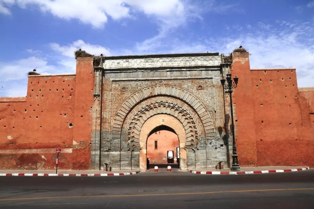Bab Agnaou monumental stone gate with carved archway set in red ramparts along the street Marrakech