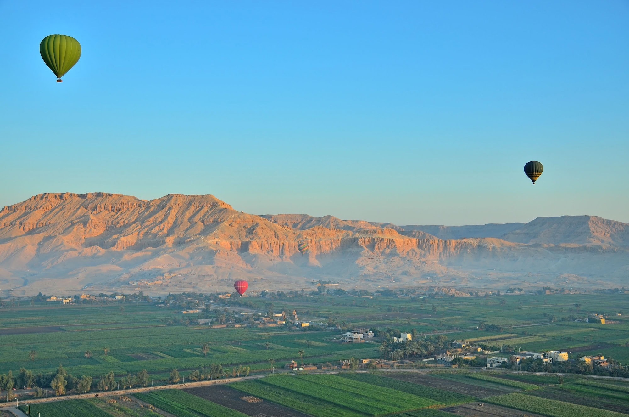 Vista aérea del Valle de los Reyes con globos aerostáticos sobre paisaje desértico