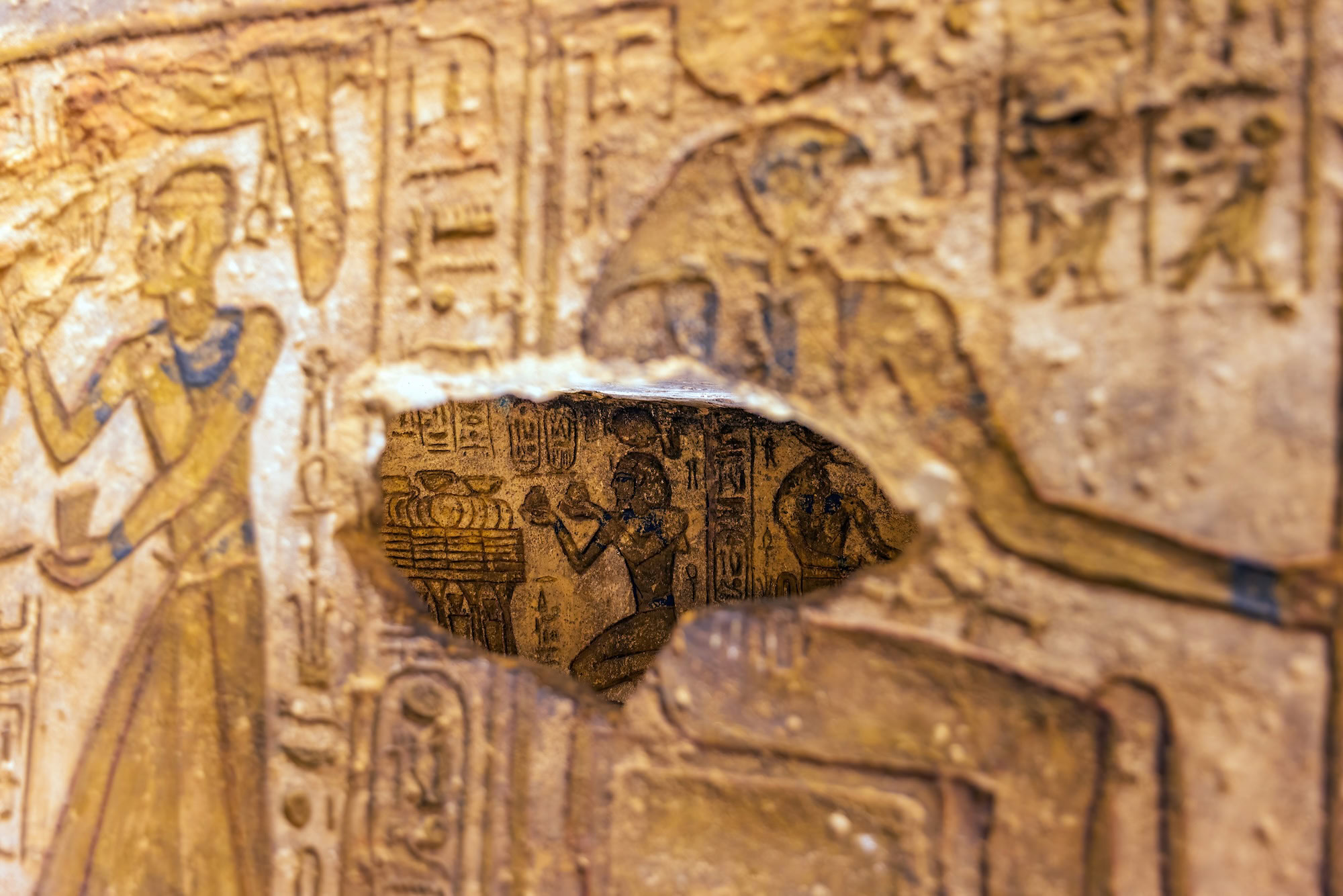 Ancient Egyptian tomb wall with hieroglyphics and painted figures depicting burial rituals