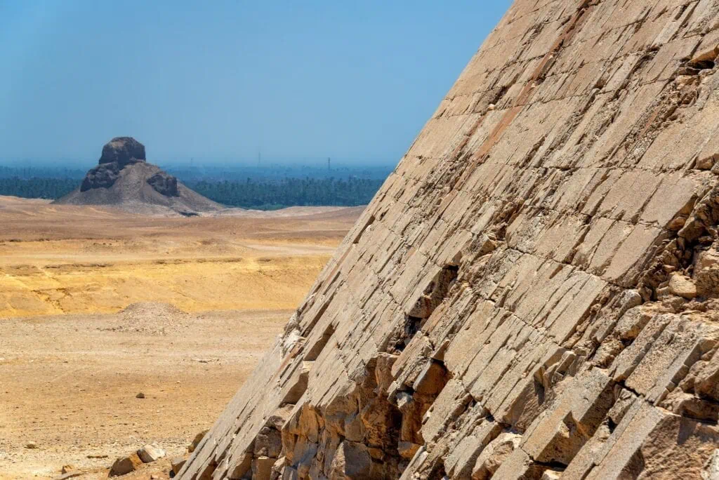 view of the Black Pyramid framed from the Bent Pyramid across the desert plateau at Dahshur