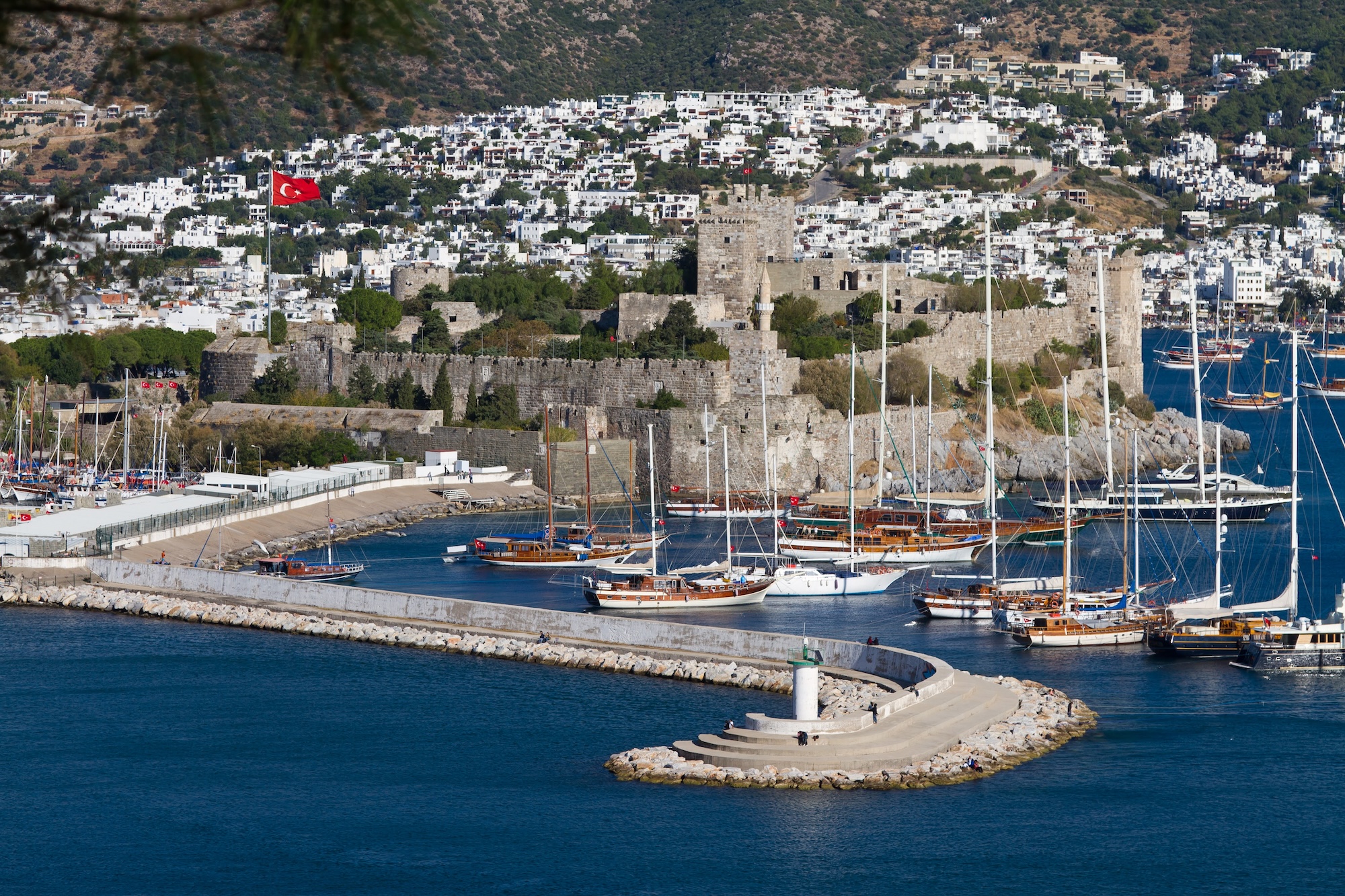 Aerial view of Bodrum Castle overlooking marina with boats and white hillside buildings