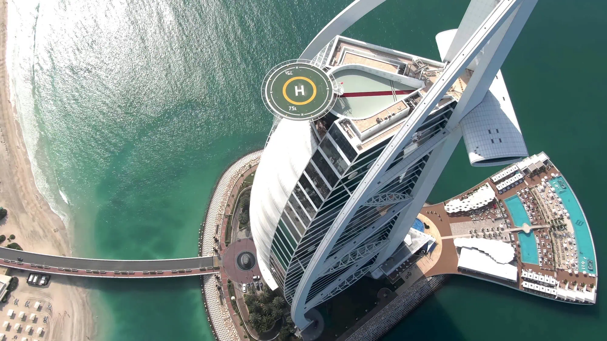 Aerial view of Burj Al Arab's iconic sail-shaped architecture with helipad