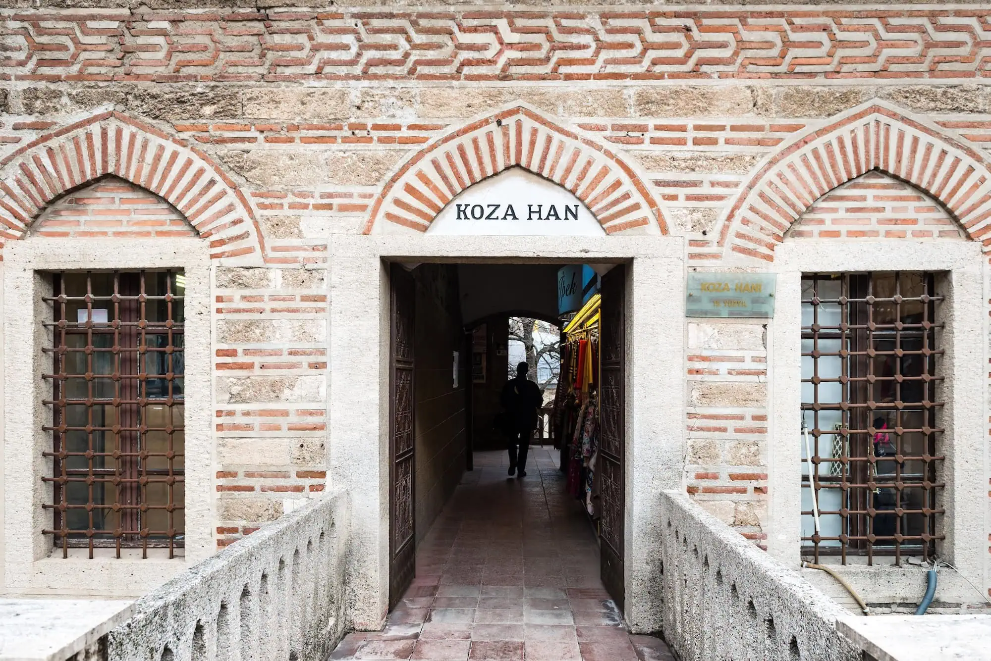 Entrance to Koza Han historic silk market with Ottoman striped arches in Bursa