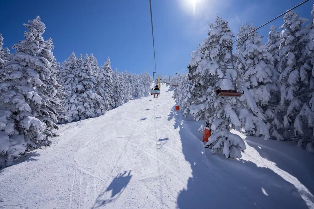 Mount Olympos ski slope with chairlift and snow-covered pine trees