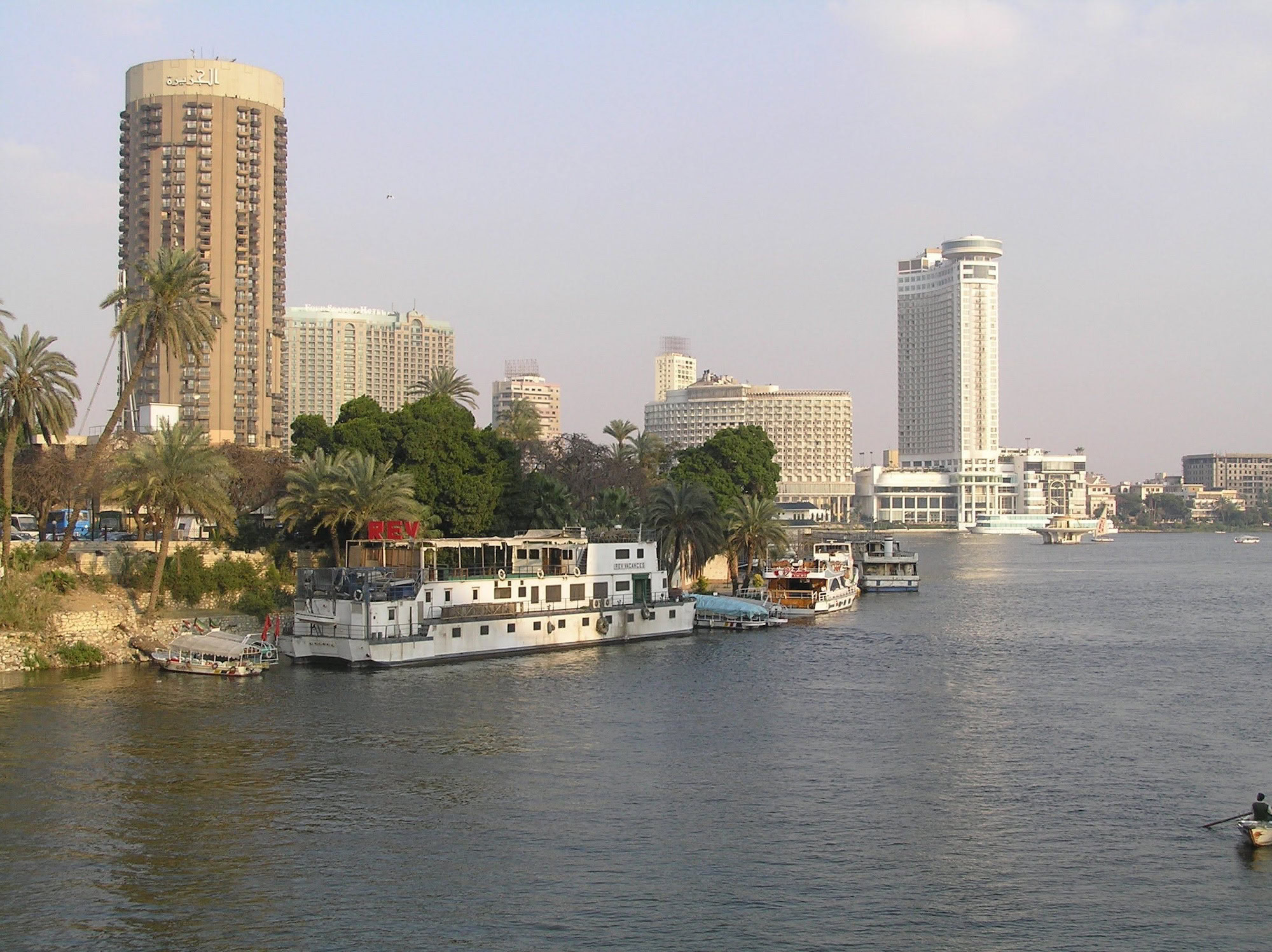 Veduta del fiume Nilo con hotel moderni e barche tradizionali al Cairo