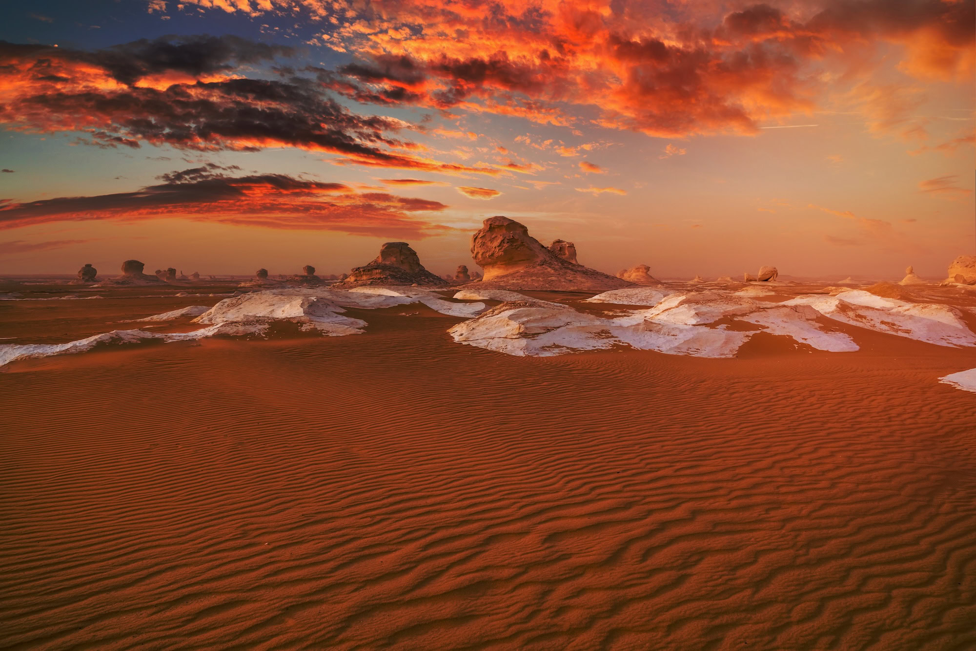 Dramatic sunset over white chalk formations in Egypt's White Desert National Park