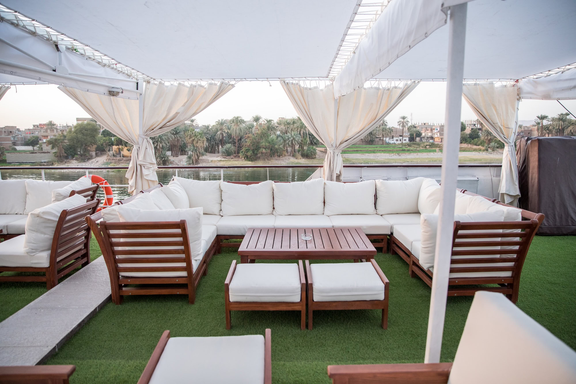 Luxurious outdoor lounge area on Nile River cruise ship with comfortable seating and palm trees