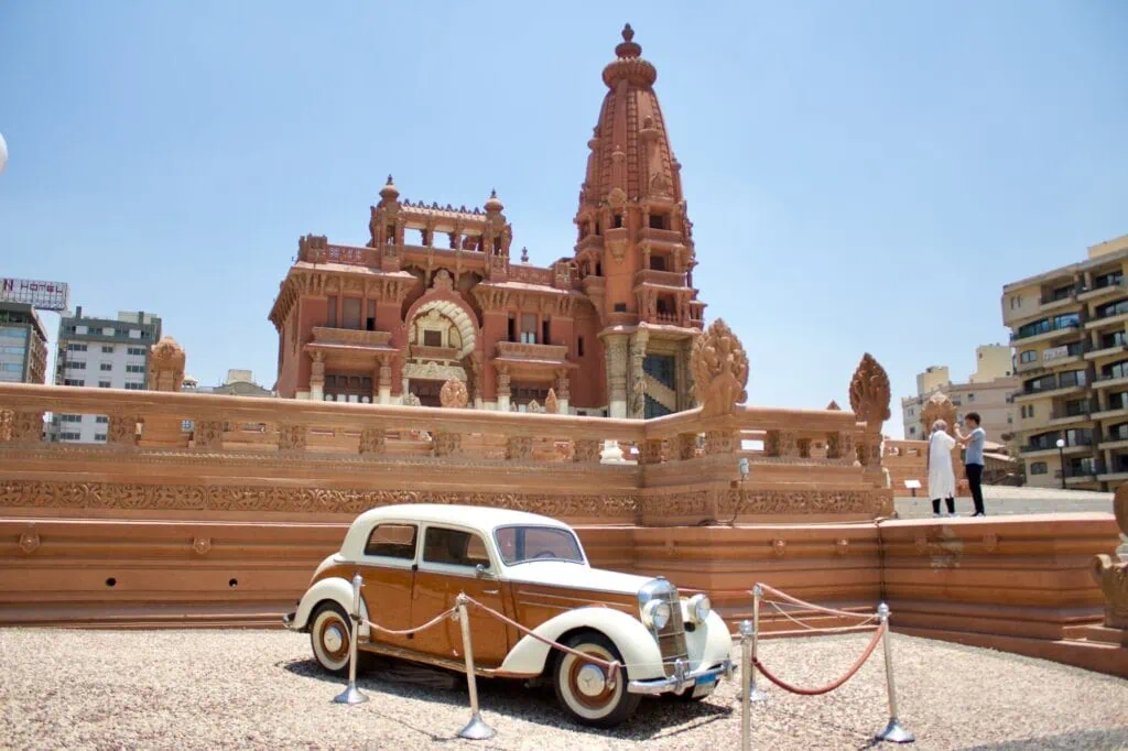 A classic car parked in front of the Baron Empain Palace, Cairo