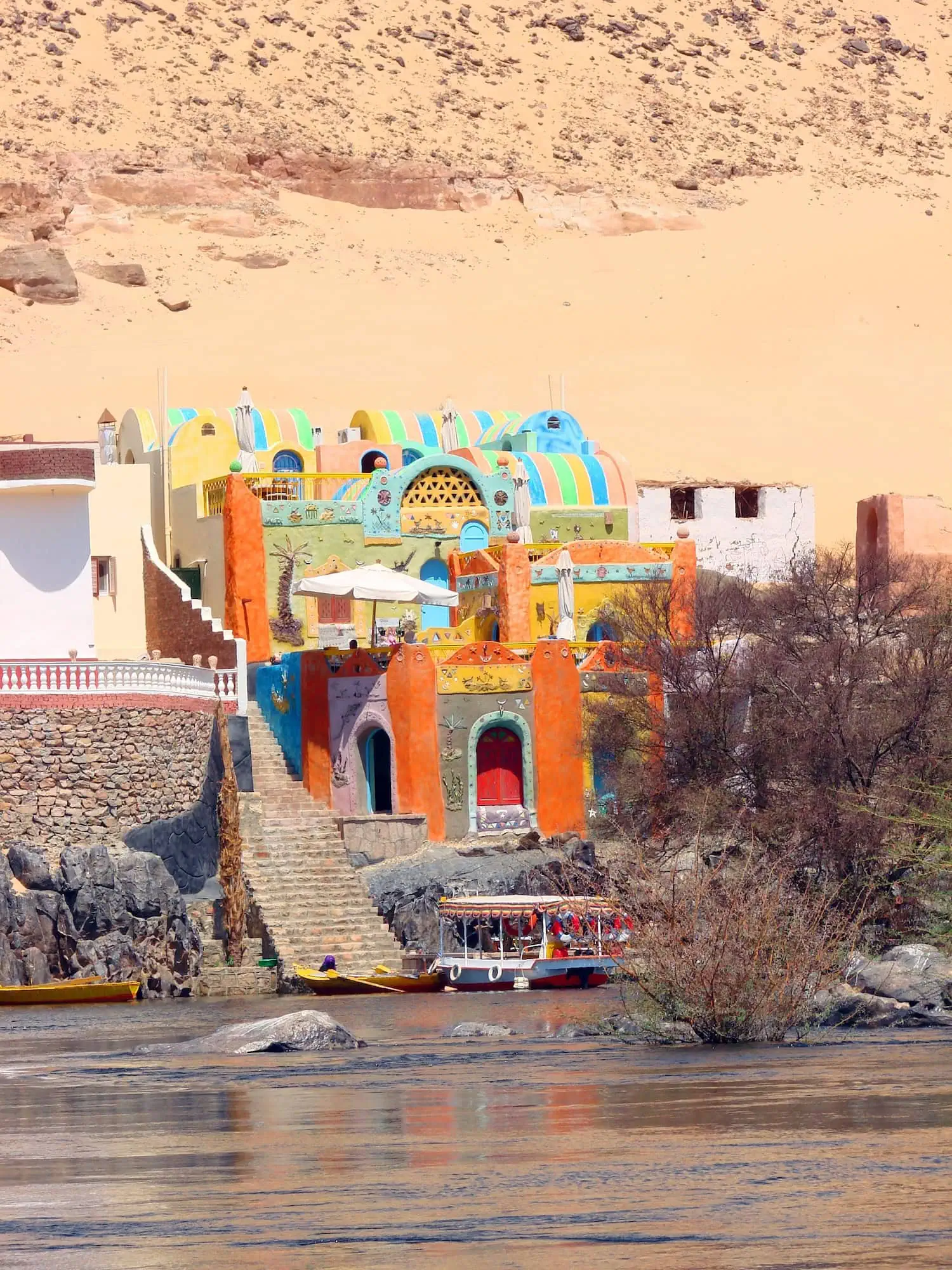Villaggio nubiano colorato sulle rive del Nilo ad Assuan con barca tradizionale