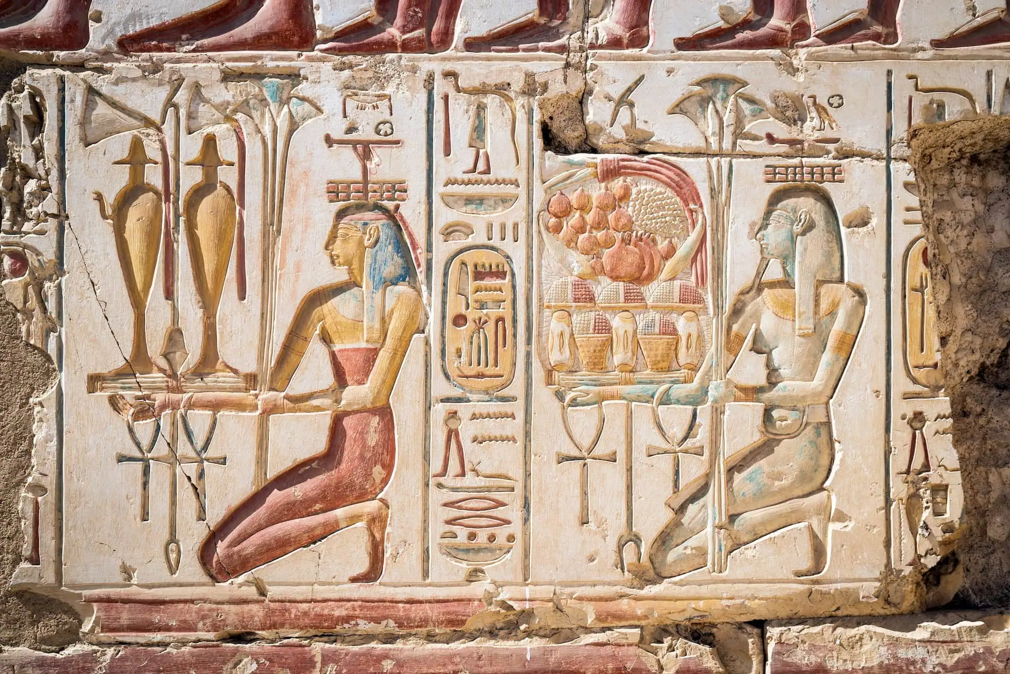Ancient Egyptian hieroglyphic inscriptions carved on temple wall with pharaonic figures and symbols