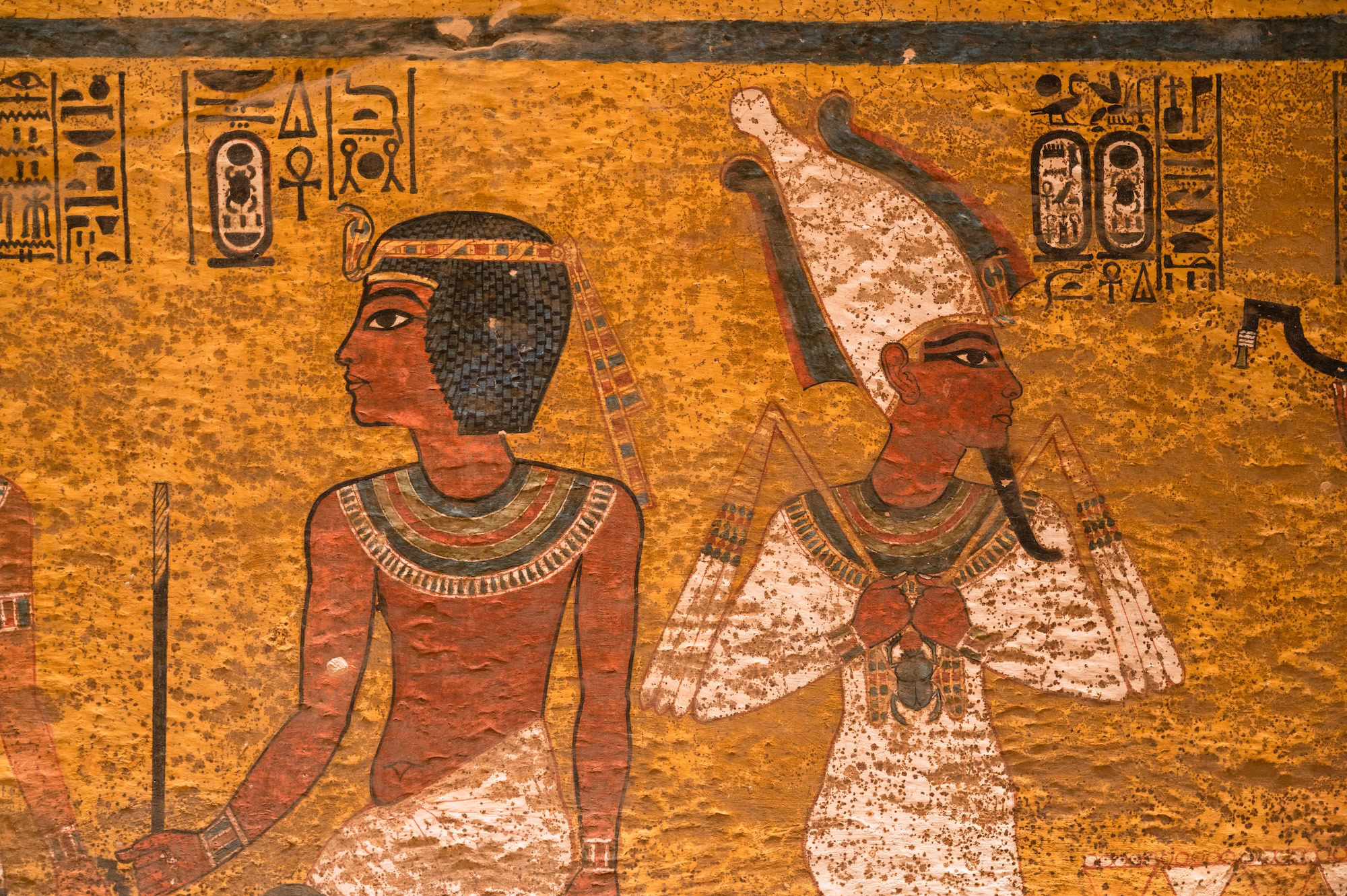 Ancient Egyptian wall paintings showing hieroglyphics and pharaoh figures from tomb
