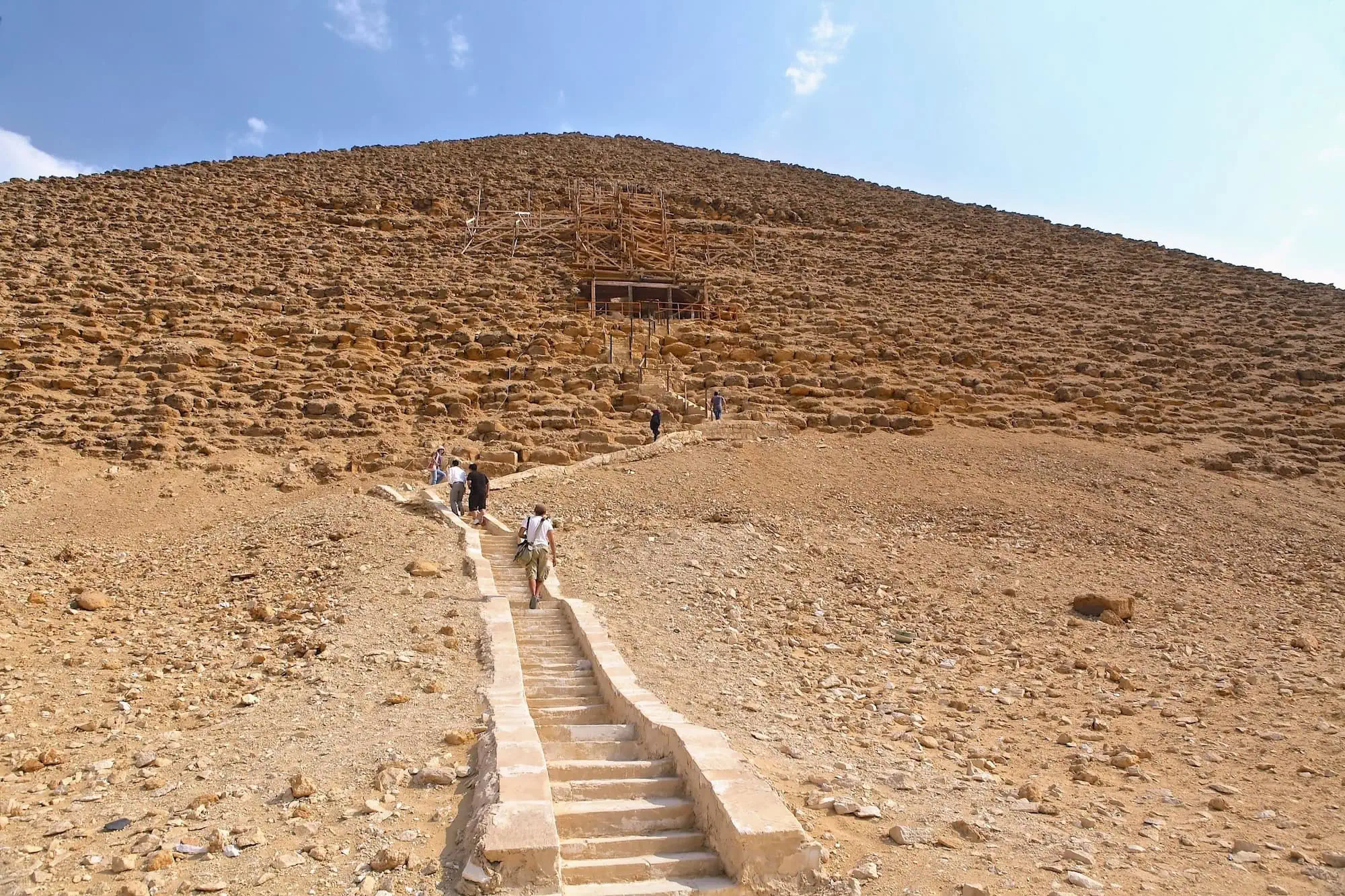 Tourists climbing stairs at the Red Pyramid in Egypt