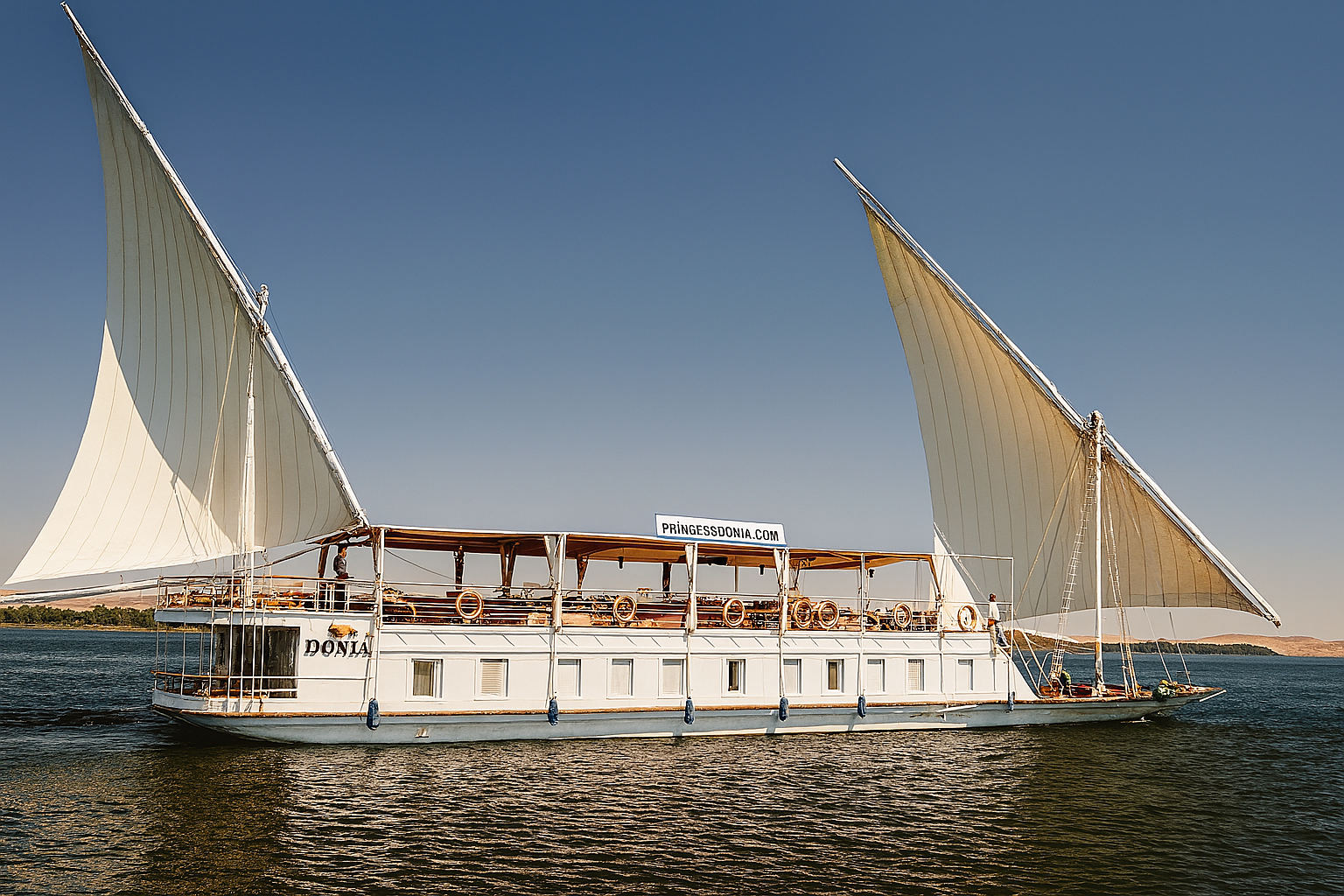 Traditional dahabiya sailboat cruising on the Nile River in Egypt