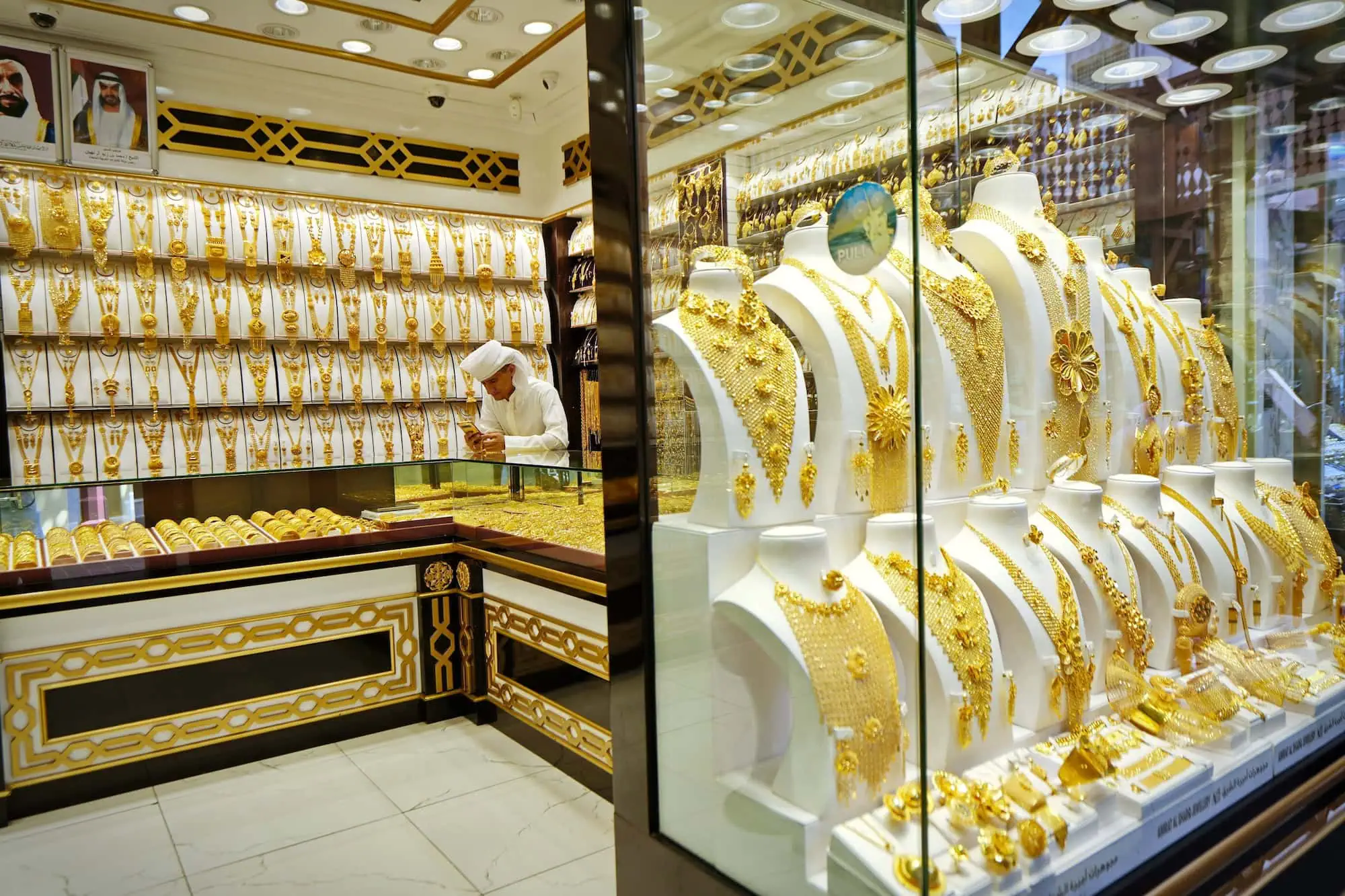 Interior of Deira Gold Souk jewelry shop with gold displays and shopkeeper