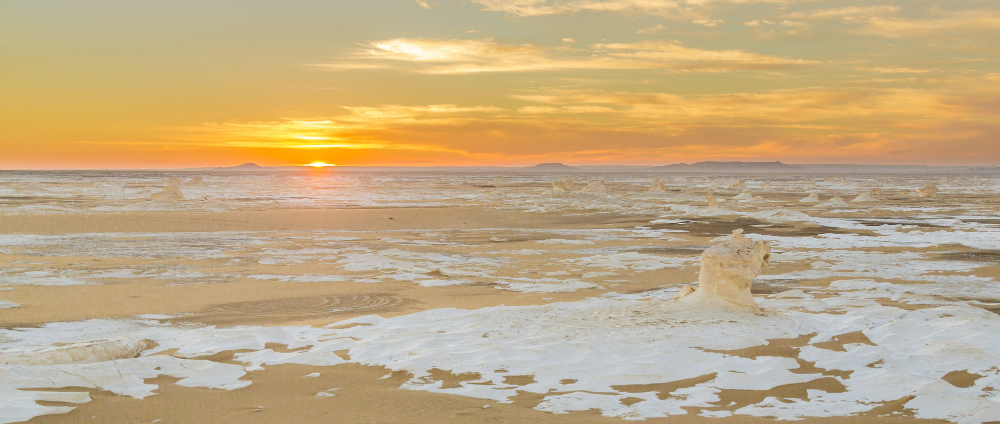 White Desert limestone formations at sunset with dramatic clouds in Egypt