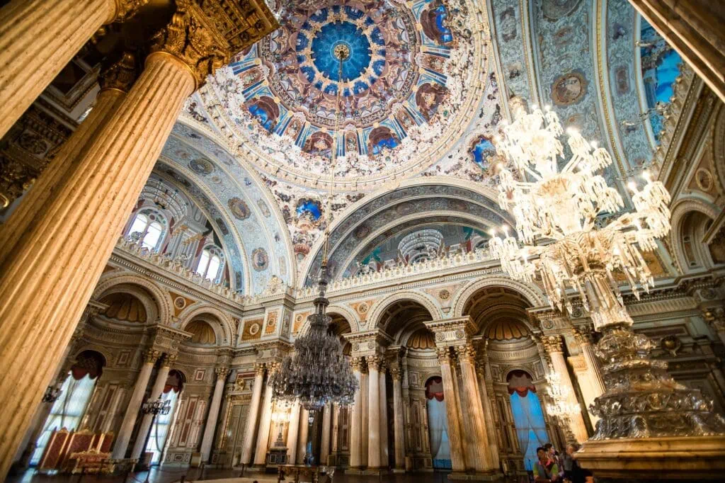 Dolmabahce Palace interior hall with ornate dome ceiling, chandeliers, and marble columns Istanbul