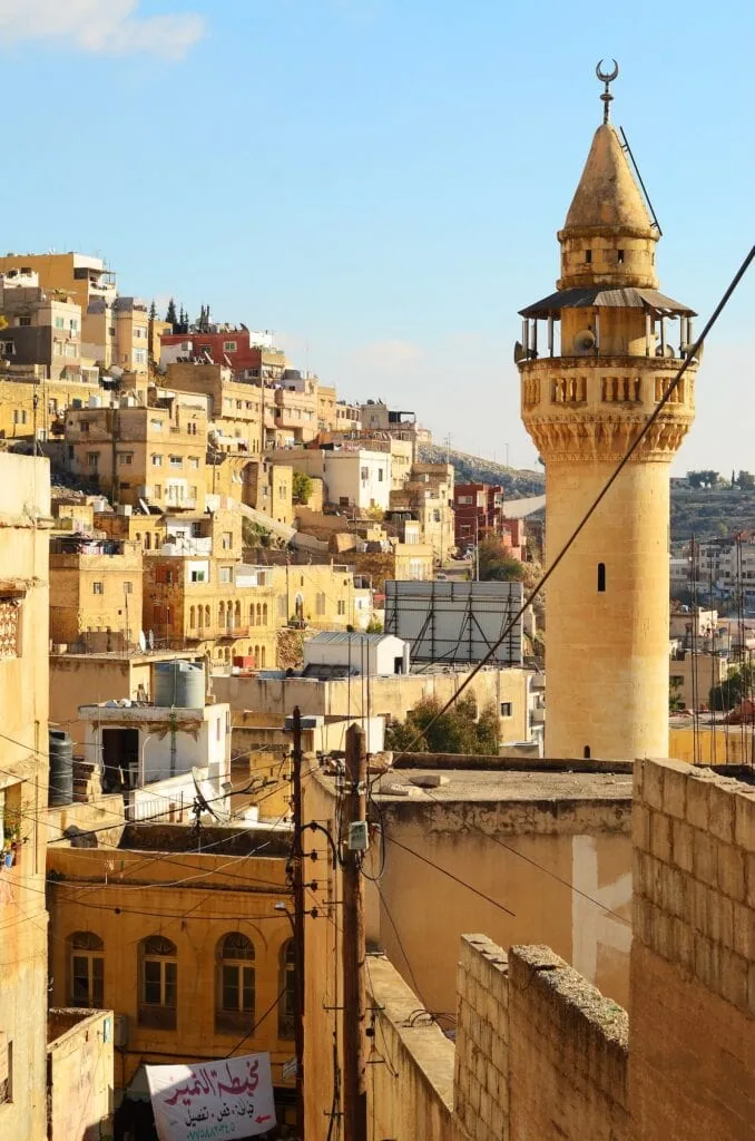 Downtown As-Salt with narrow streets, stone buildings, shops, and pedestrians along the hillside, As-Salt
