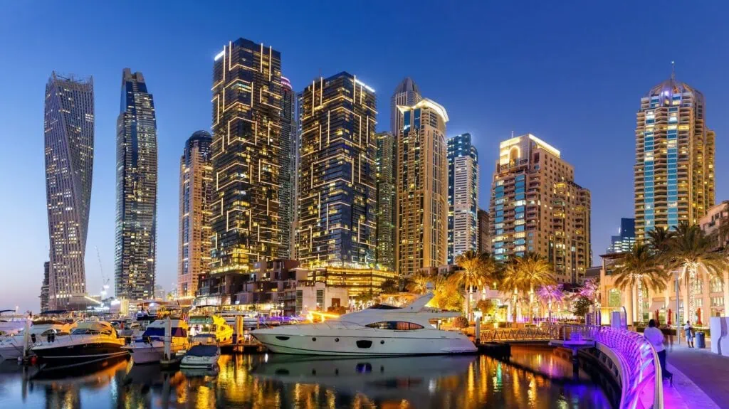 Dubai Marina skyline with illuminated towers and yachts at night, Dubai
