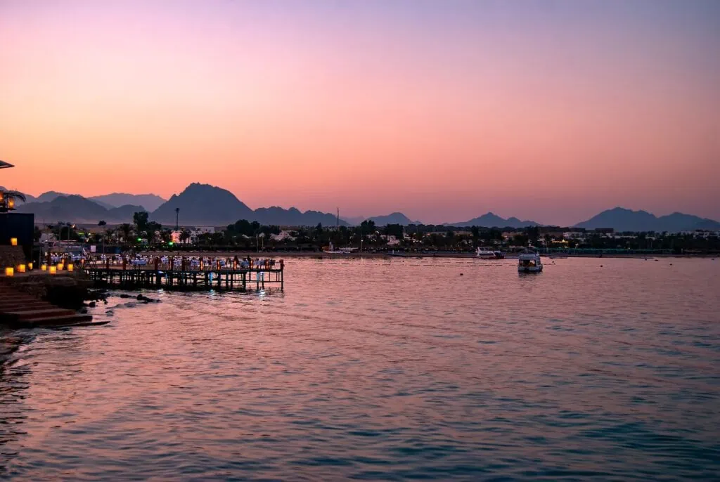 Dusk view over Naama Bay with beachfront hotels and boats along the shoreline, Sharm el Sheikh