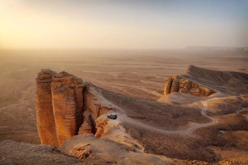 View from the Edge of the World (Jebel Fihrayn) in Saudi Arabia — a dramatic 300-metre limestone escarpment overlooking the desert plain, accessible by 4WD from Riyadh