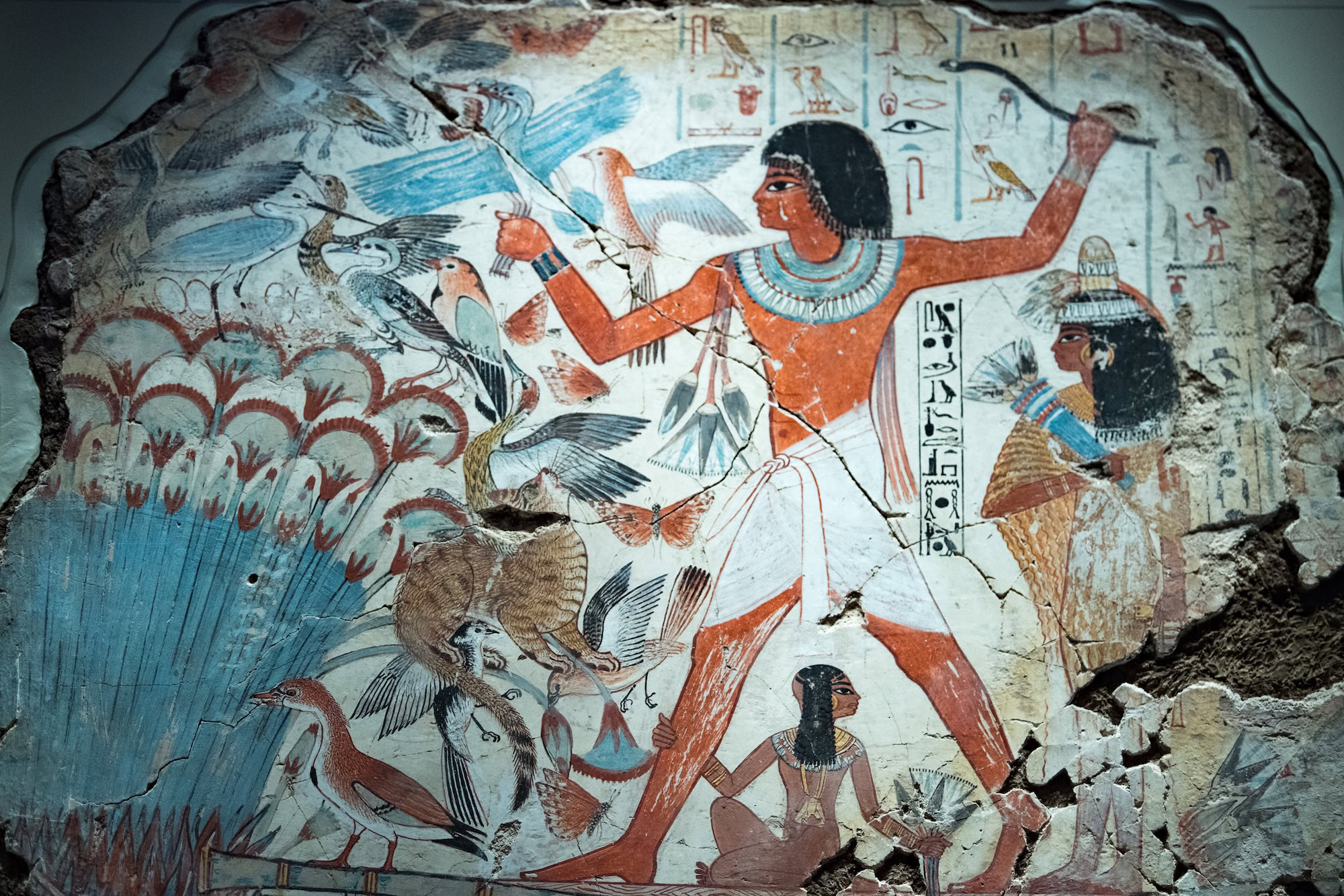 Ancient Egyptian wall painting showing figures with bow and arrow, birds, and papyrus plants