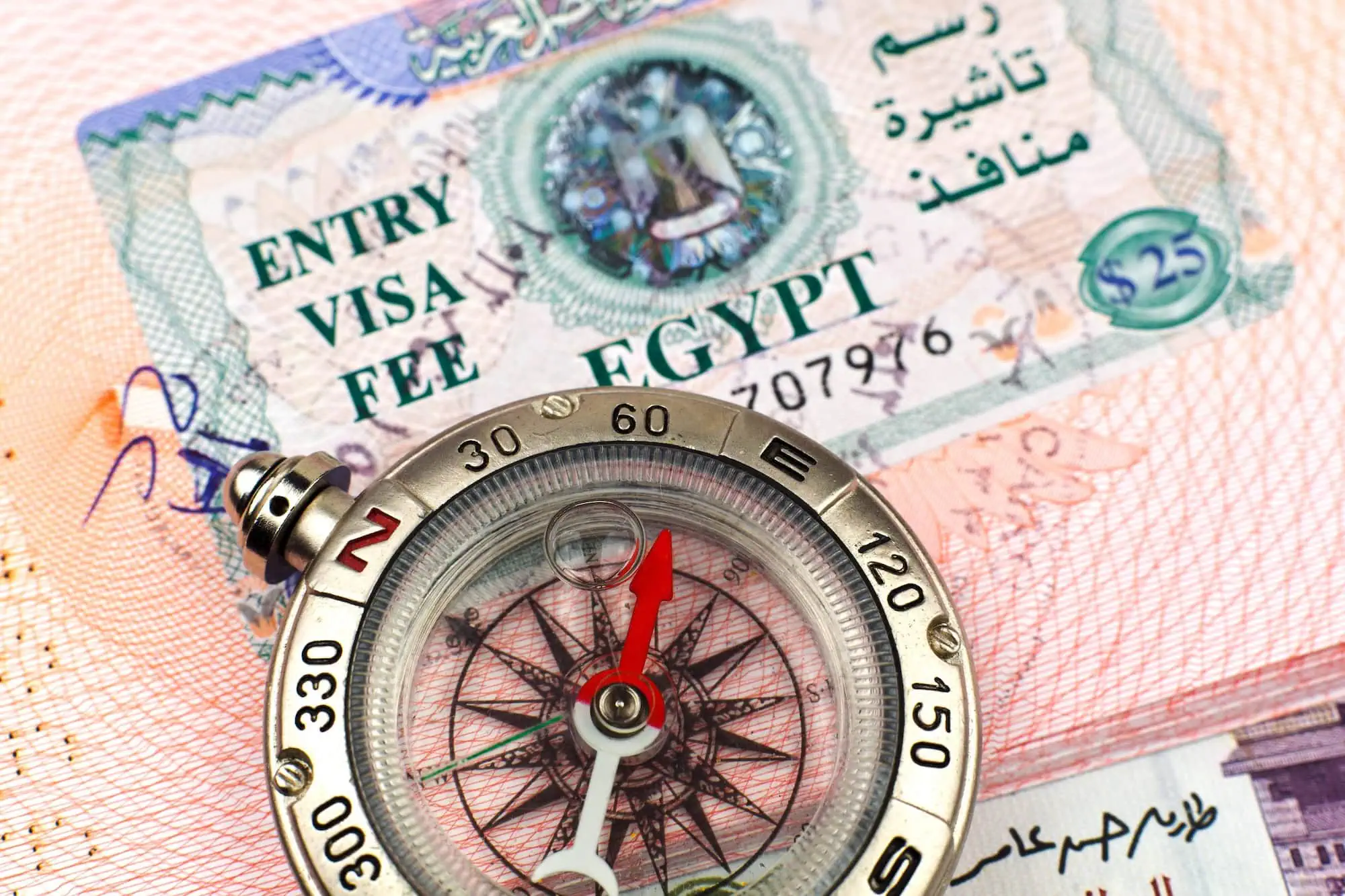 Travel documents including passport, visa, compass and currency for Egypt travel