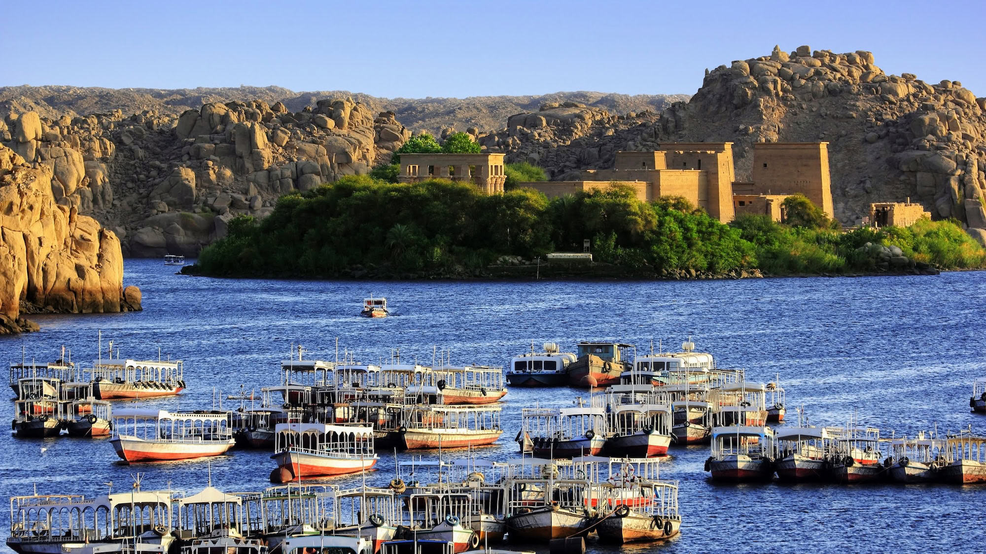 Philae Temple complex on the Nile River in Aswan with tourist boats and ancient ruins