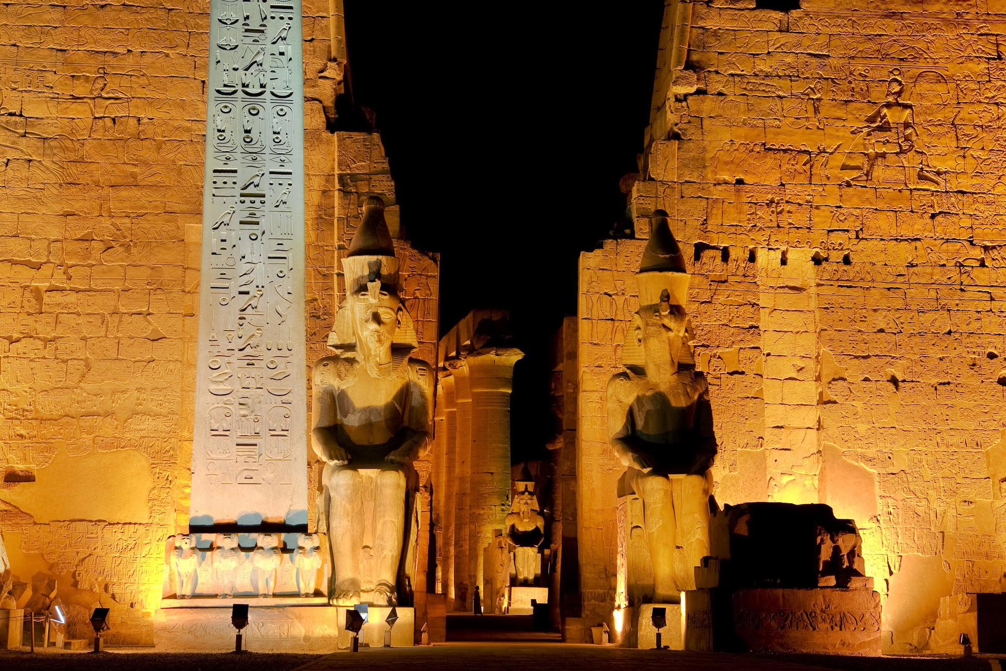 Majestic Luxor Temple with towering pharaoh statues, obelisk, and hieroglyphic-covered columns