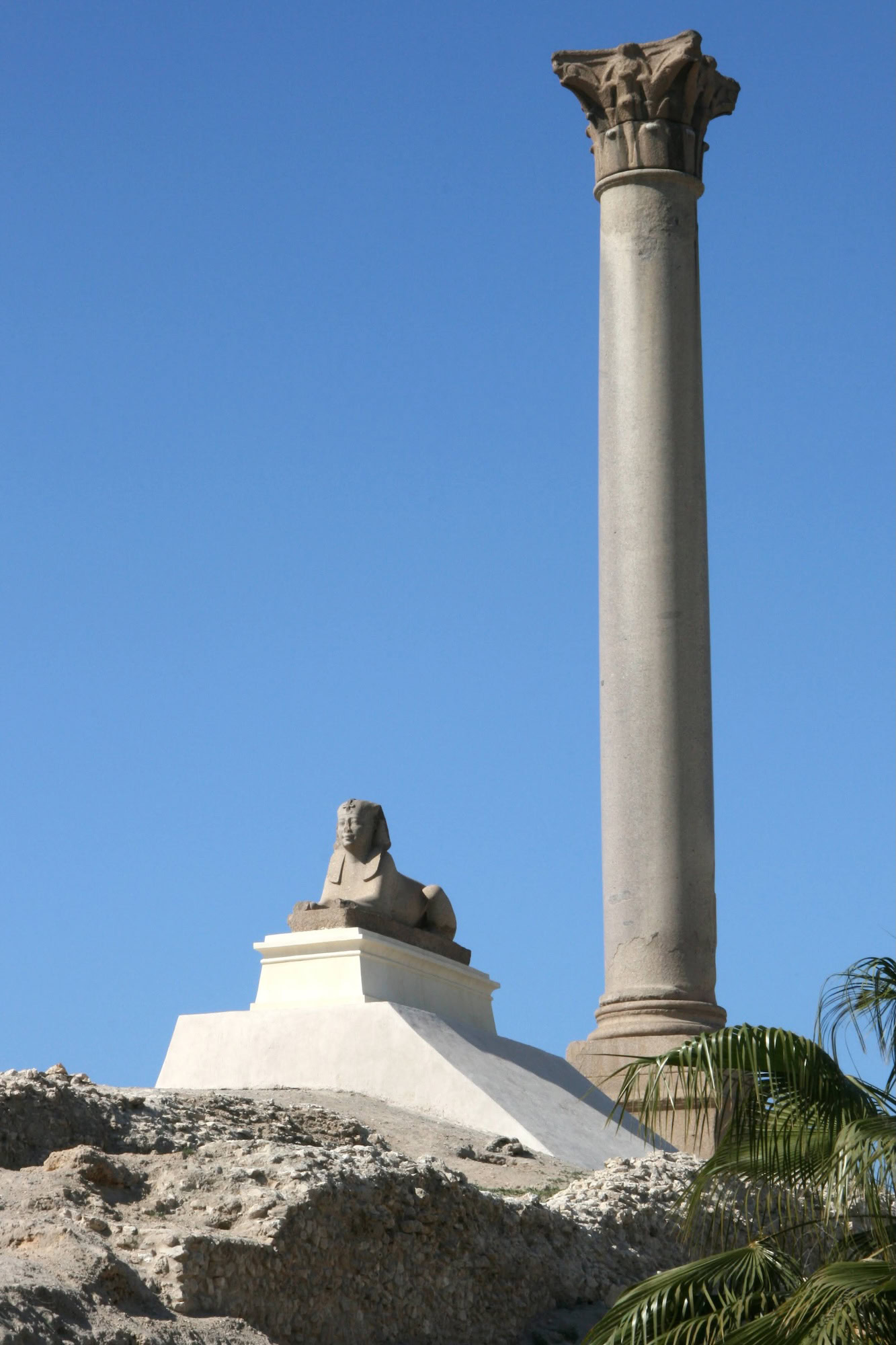 Pompey's Pillar in Alexandria with sphinx statues and ancient Roman ruins