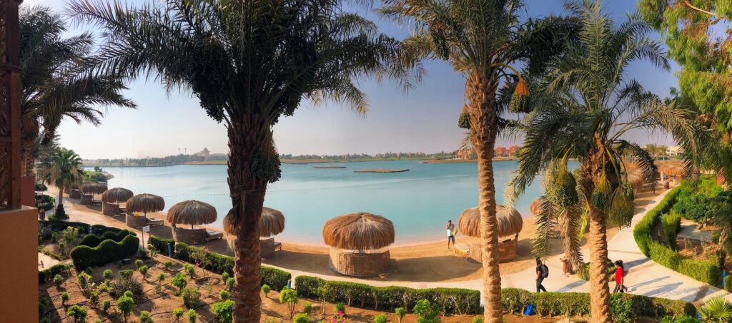 Palm-lined resort with walkways beside calm blue water in El Gouna