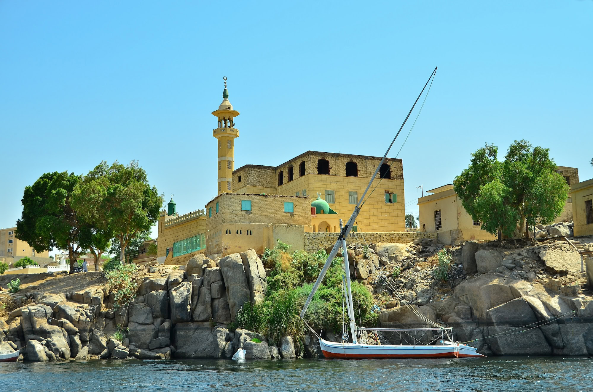 Traditional Nubian mosque with minaret and dome along the Nile River waterfront in Aswan