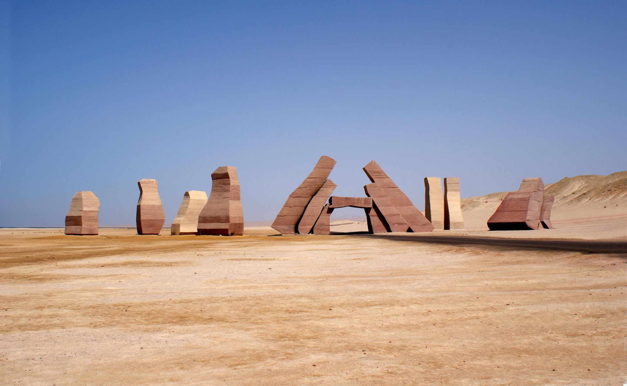 Stone letters spelling Ras Mohammed in desert landscape with clear sky
