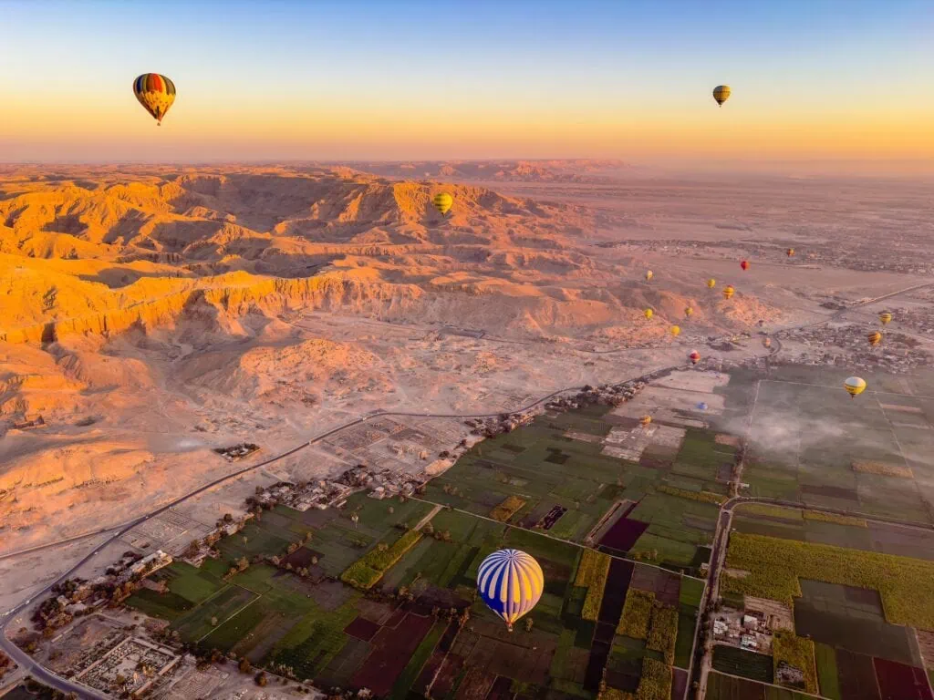 Aerial view of Valley of the Kings with hot air balloons over ancient royal tombs