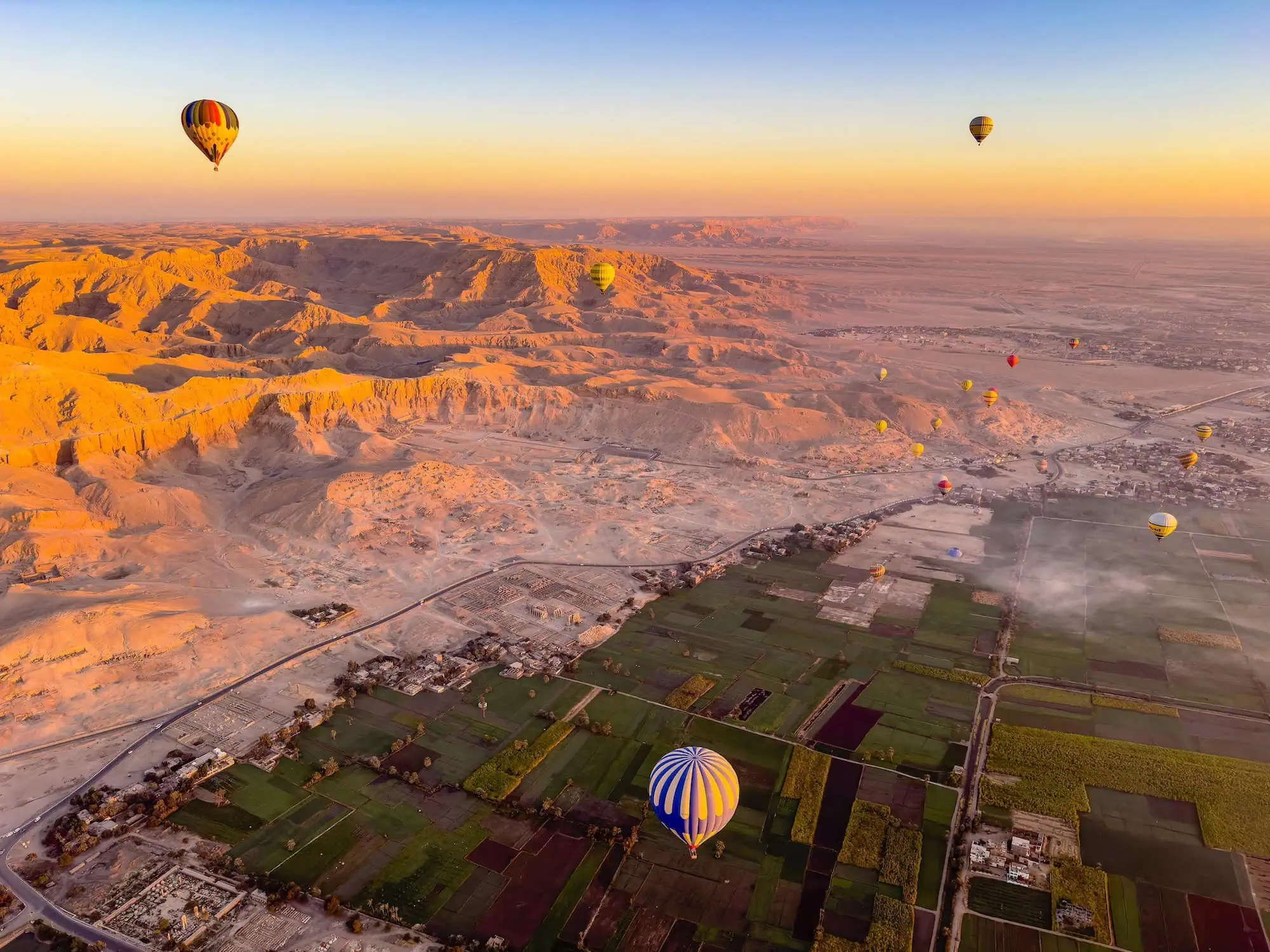 Aerial view of Valley of Kings with hot air balloons over ancient tombs