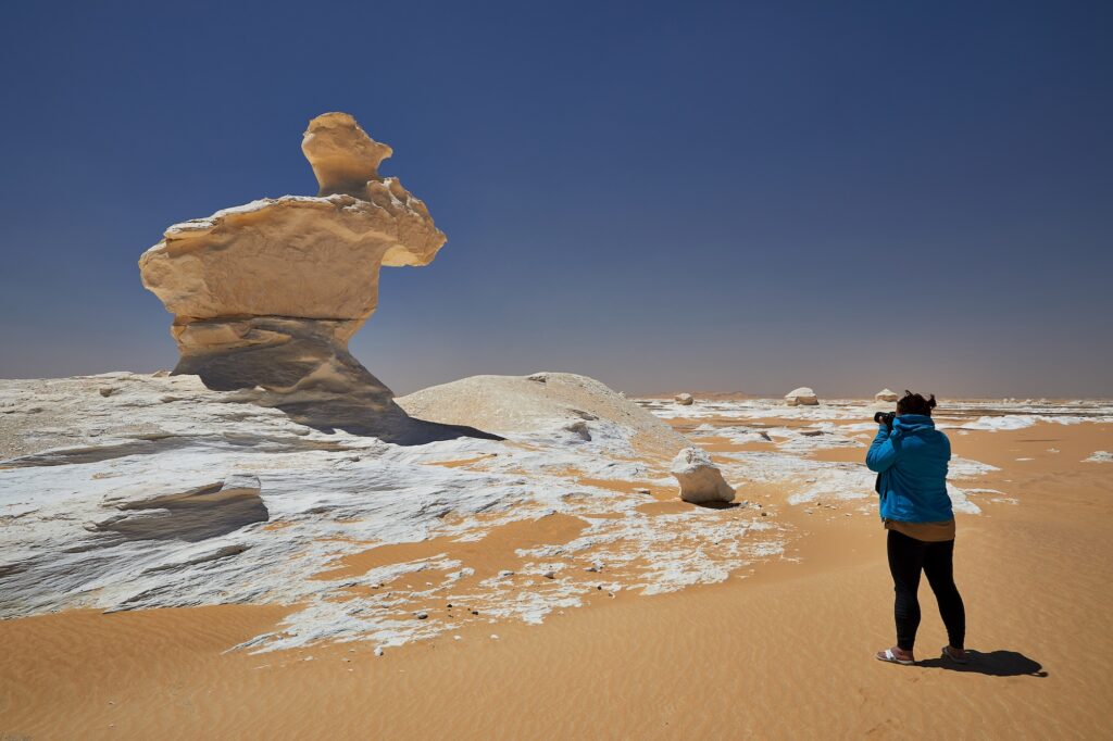 Farafra, Egypt - A photographer taking pictures of a rock that looks like a moose