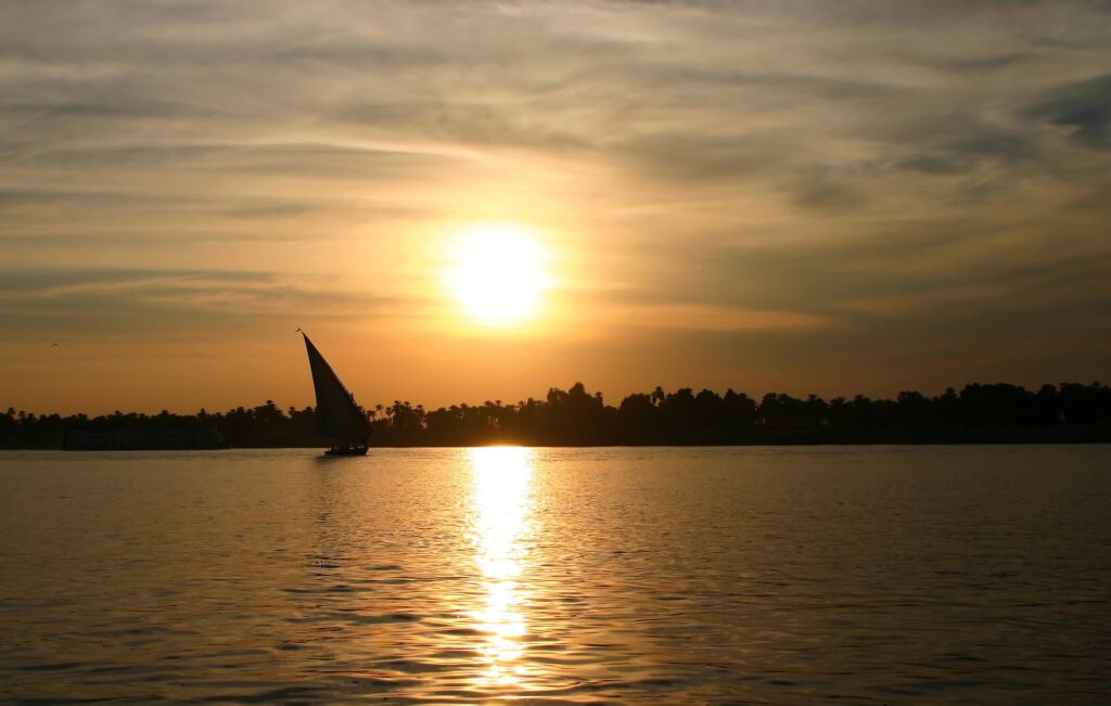 Felucca sailing on the River Nile against sunset