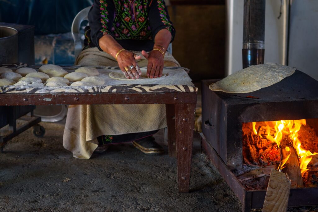 Elder Arab woman’s hands baking traditional taboon flatbread